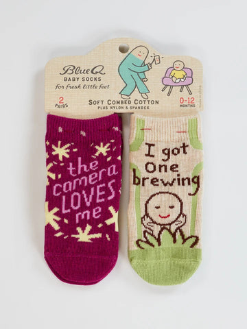 Blue Q The Camera Loves Me/ I Got One Brewing Baby Socks